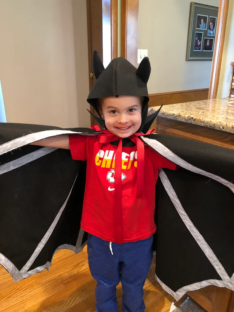 Child wearing handmade fabric bat costume wings