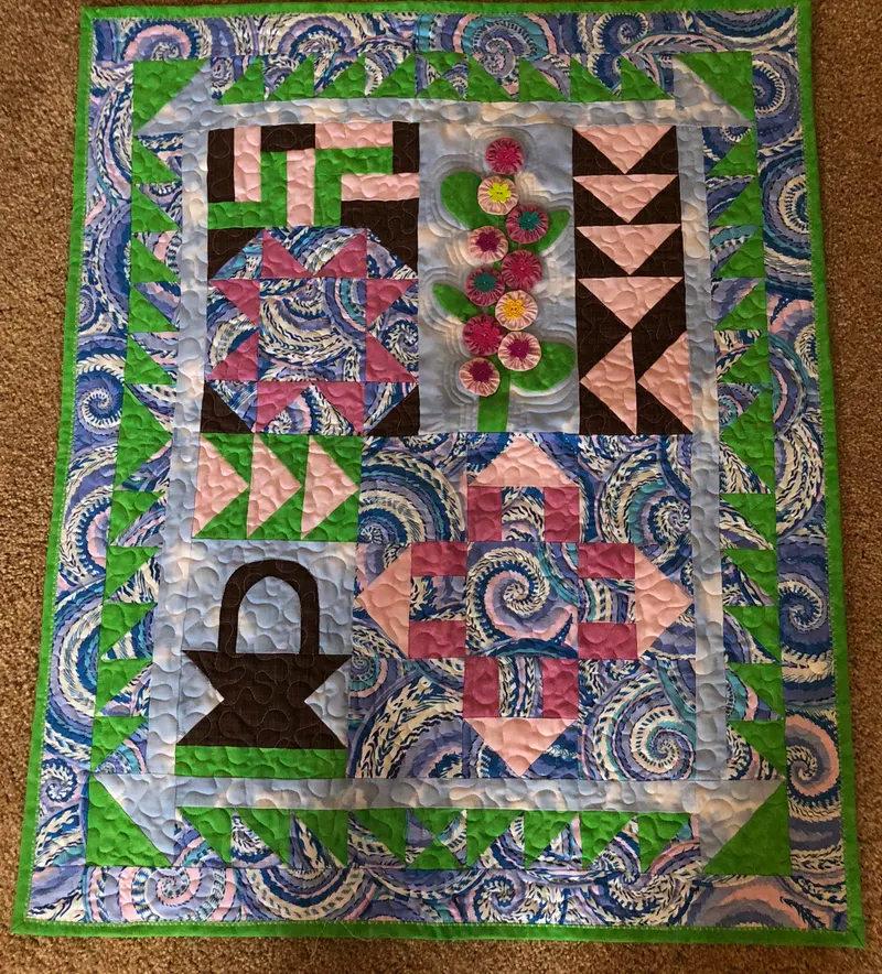 Sampler with basket, flower, and pinwheel blocks in blue and green