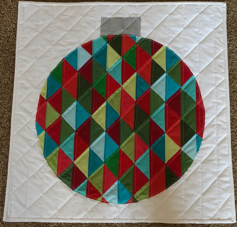 Christmas ornament mini quilt with colorful triangles