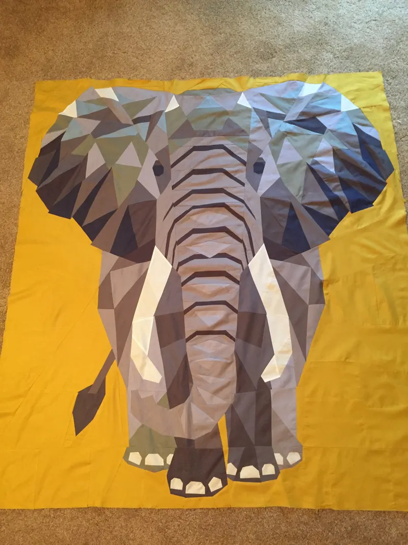 Geometric low-poly elephant on bold gold background