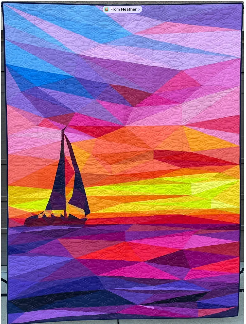 Sailboat silhouette against vivid sunset over water