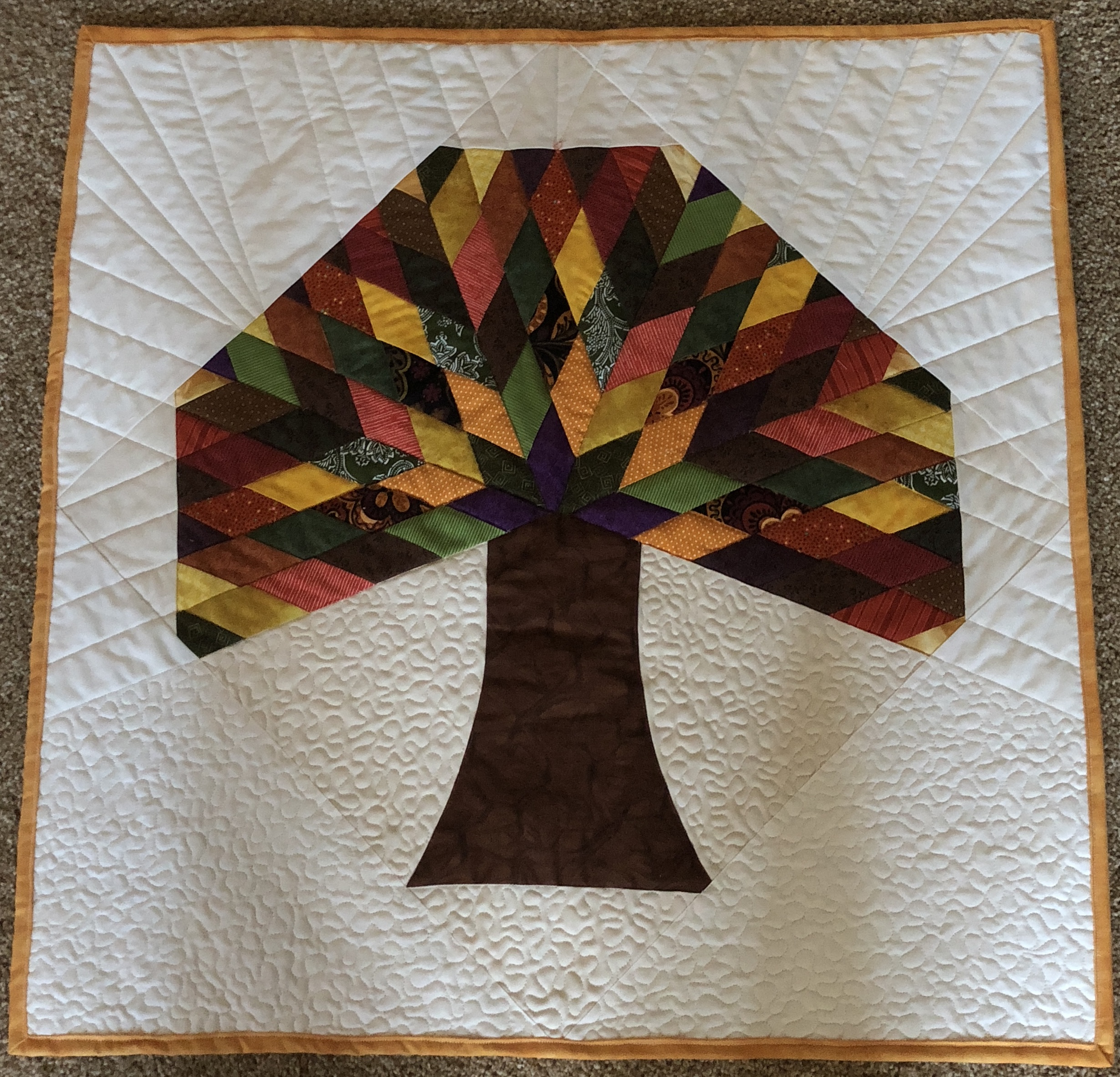 Fall tree with pieced leaf canopy in warm harvest colors