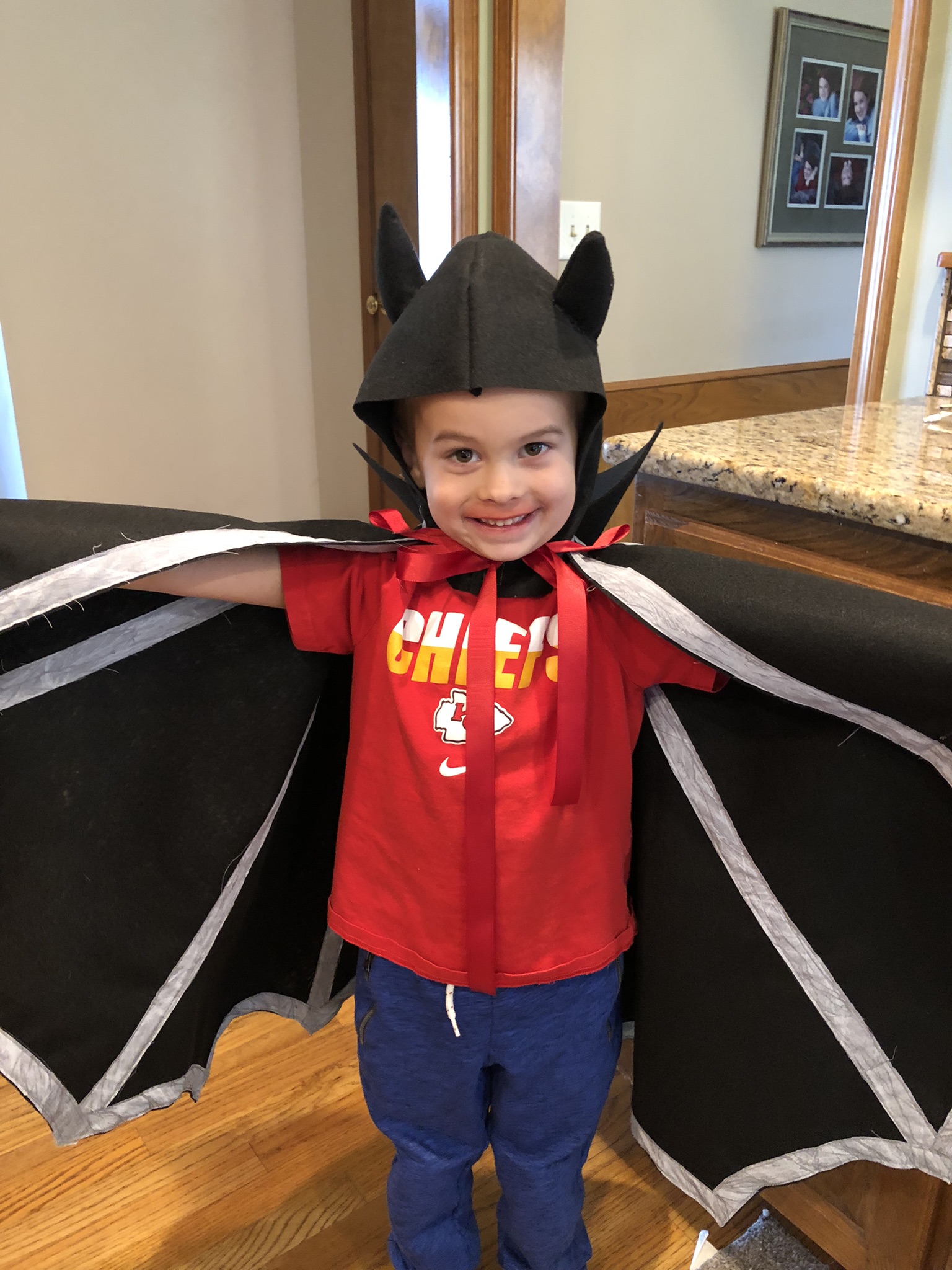 Child wearing handmade fabric bat costume wings