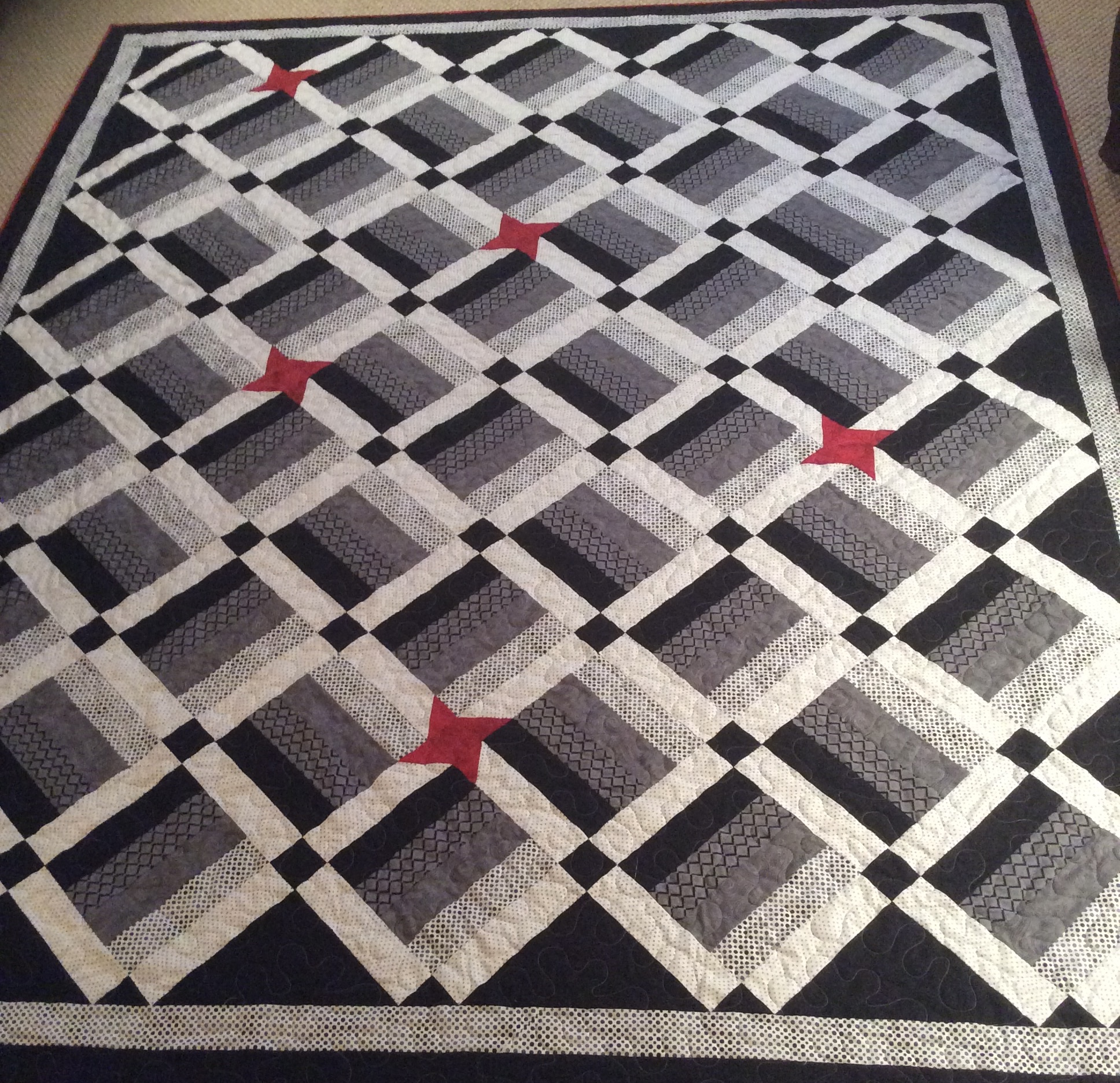 Black and white geometric lattice with red pinwheel stars
