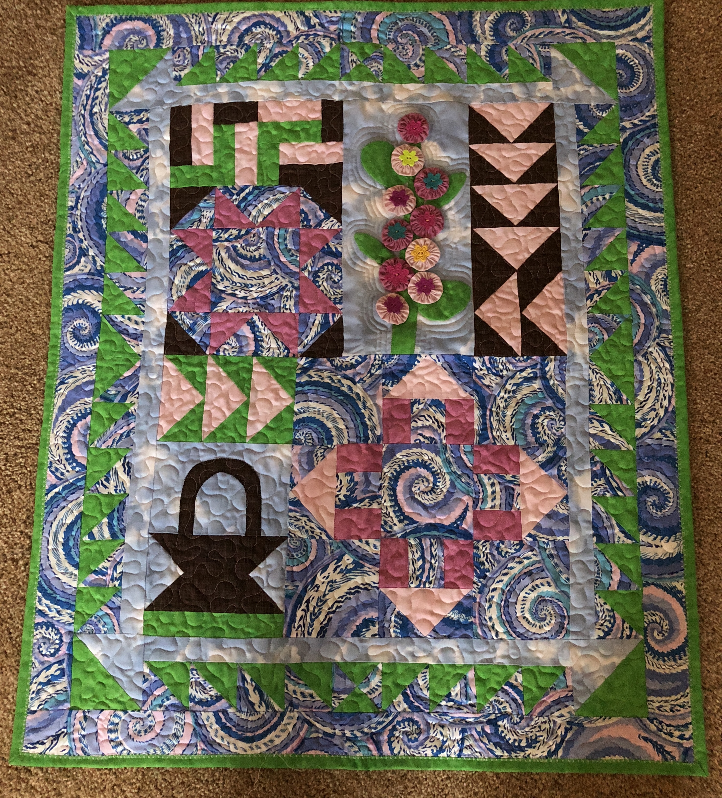 Sampler with basket, flower, and pinwheel blocks in blue and green