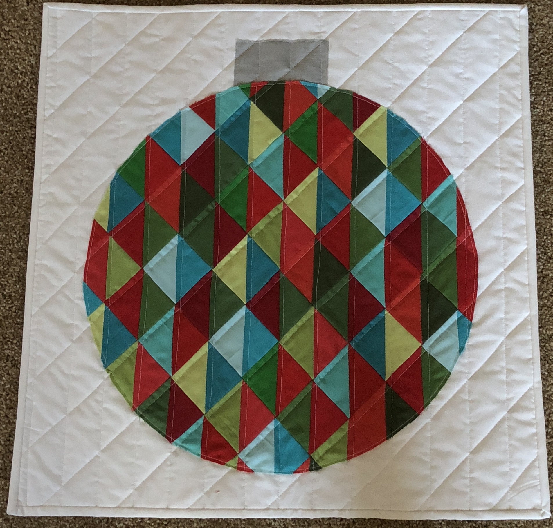 Christmas ornament mini quilt with colorful triangles