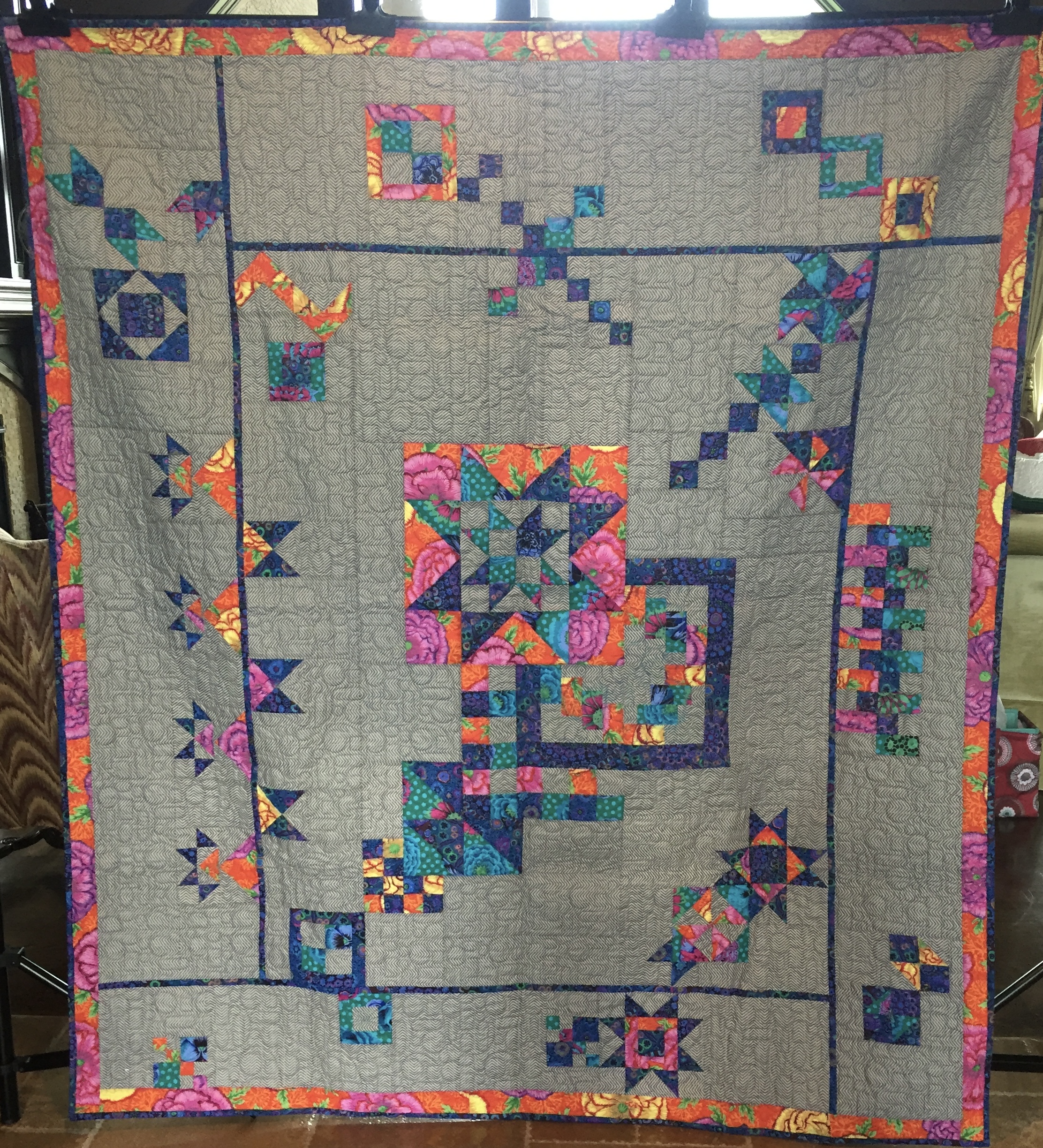 Modern sampler with jewel tone stars on gray linen