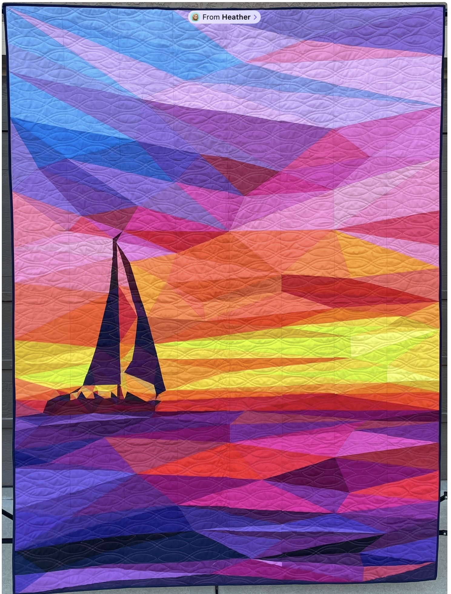 Sailboat silhouette against vivid sunset over water
